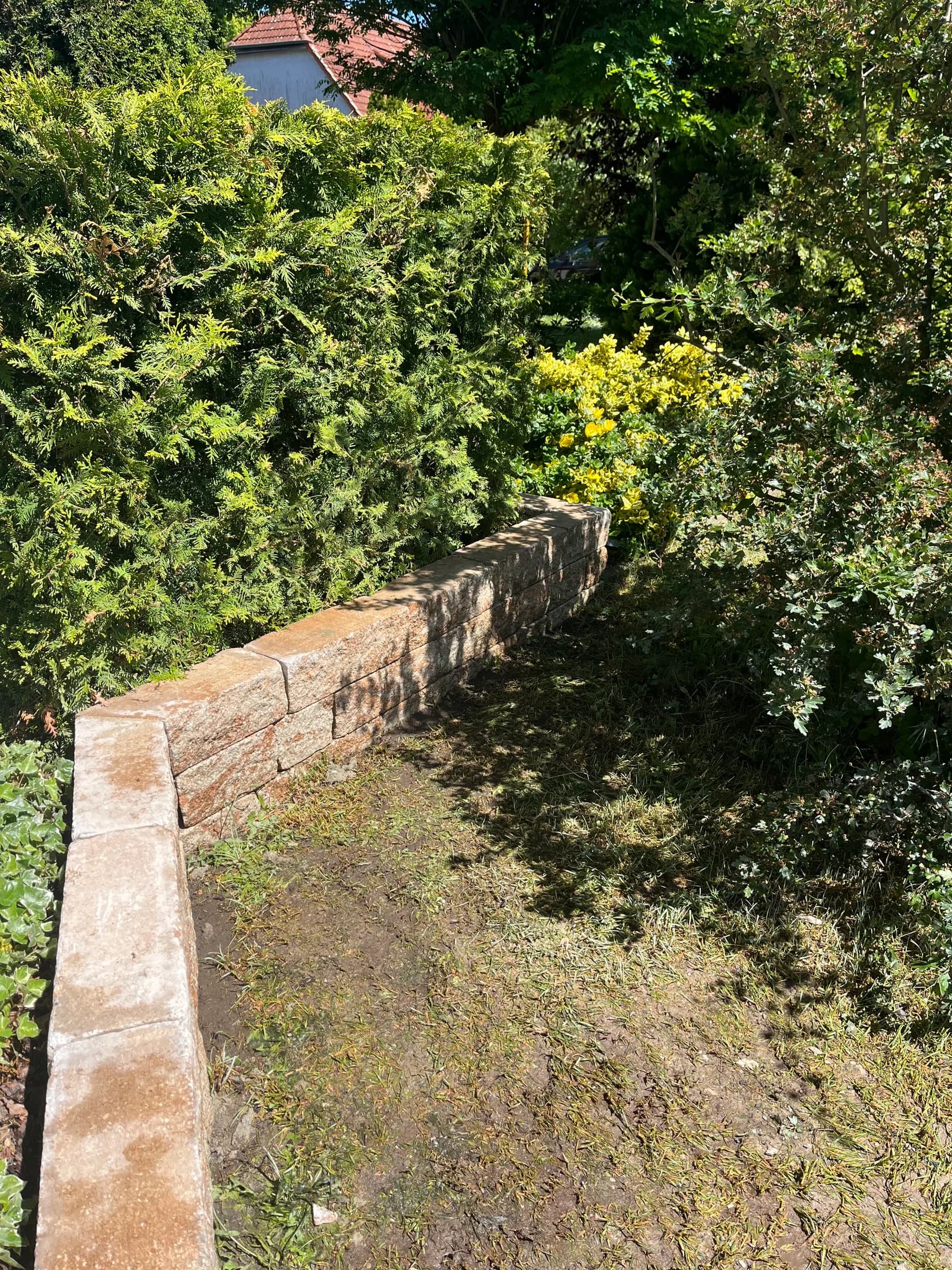 Mauer aus Naturstein als Einfassung eines Gartens
