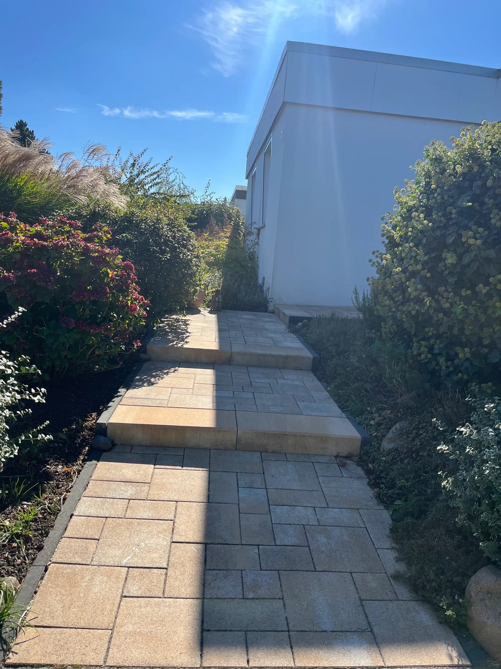 Sorgfältig verlegter Gartenweg aus Steinplatten
